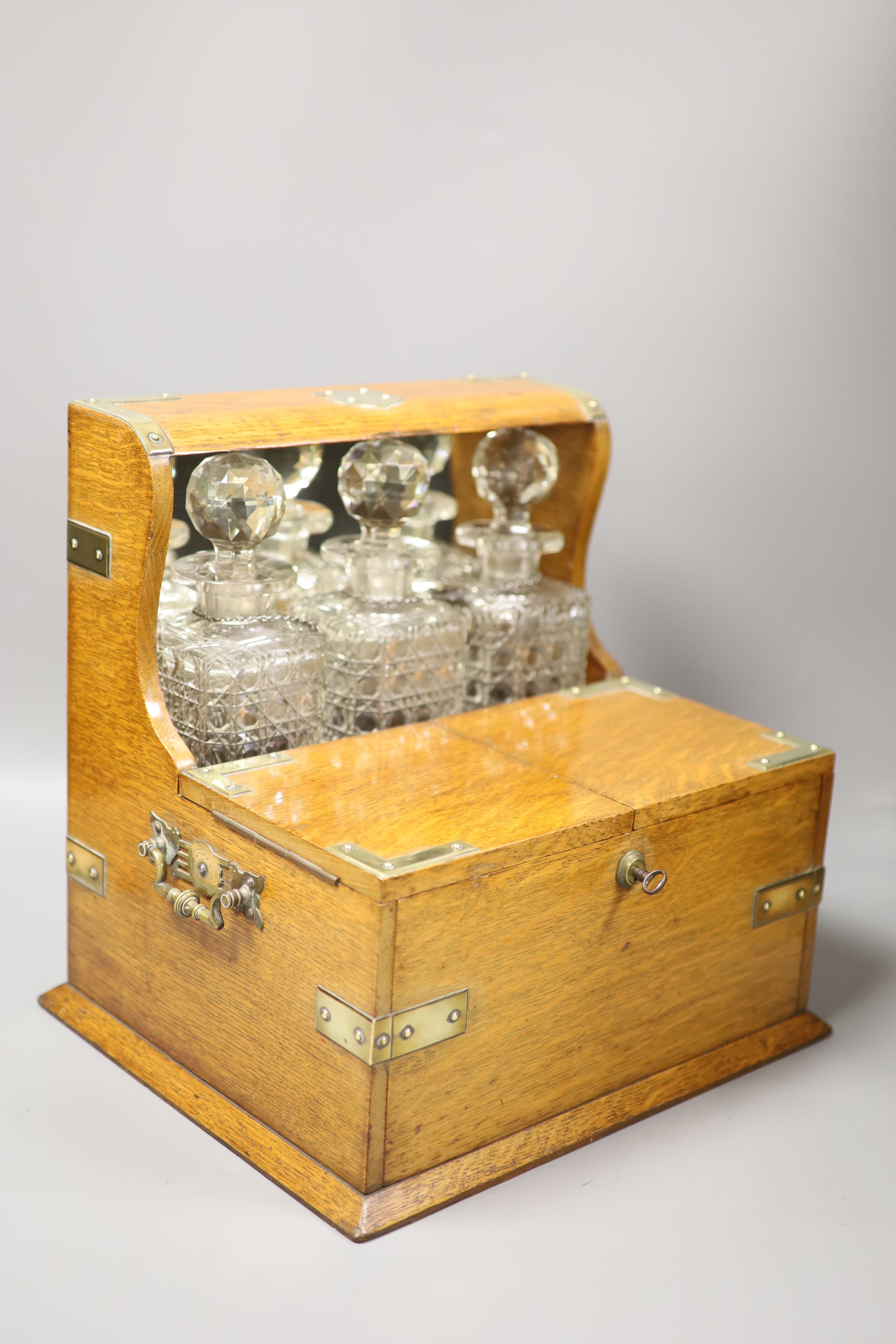 A good Victorian oak and brass mounted tantalus and combination games box, height 35.5cm width 36cm depth 30cm